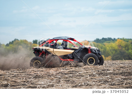 Red buggy with two people in helmets on plowed 37045052