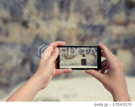 Female taking picture of old stone house in Matera 37045070
