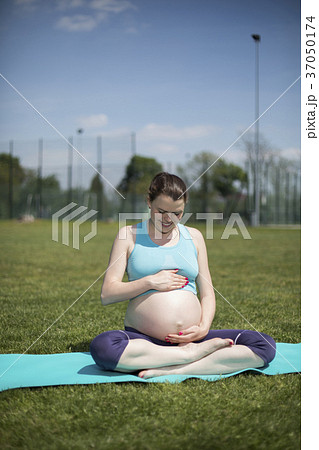 Healthy pregnant woman doing yoga in nature. Healthy pregnant woman doing yoga in nature. 37050174
