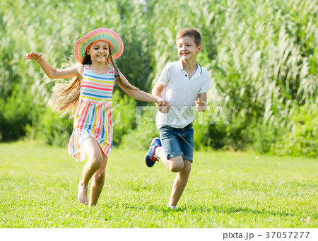 Two children running in park. 37057277