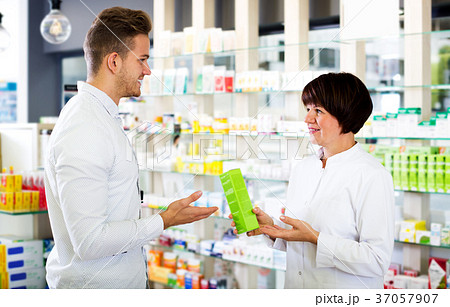 Woman druggist wearing white coat 37057907
