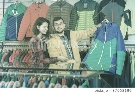 Guy and the girl are watching the choice of jackets Guy and the girl are watching the choice of jackets 37058196