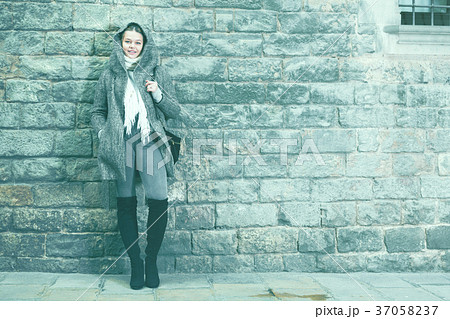 teenager girl in hood near wall teenager girl in hood near wall 37058237