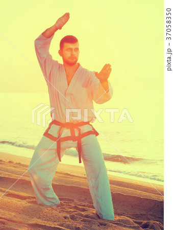 Man doing karate at ocean Man doing karate at ocean 37058350