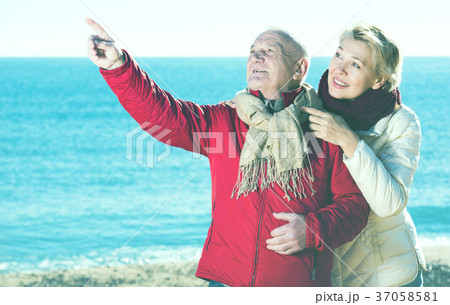 Mature couple pointing on beach Mature couple pointing on beach 37058581