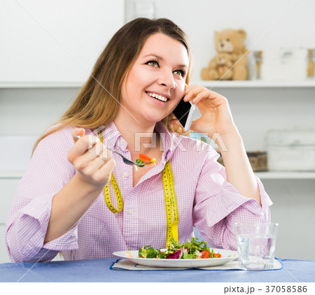 Young woman is enjoying tasty green salad Young woman is enjoying tasty green salad 37058586