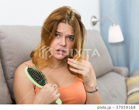 Young woman is nervous because her hair suffers from avitaminosis Young woman is nervous because her hair suffers from avitaminosis 37059168