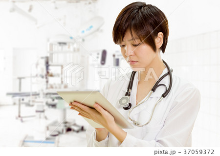 Asian female doctor using tablet computer in clinic Asian female doctor using tablet computer in clinic 37059372
