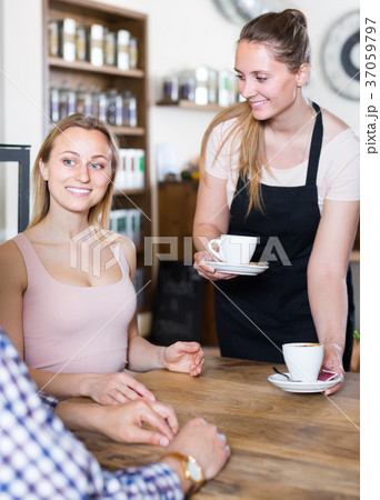polite waiter girl brought cup of coffee for couple of different aged people 37059797