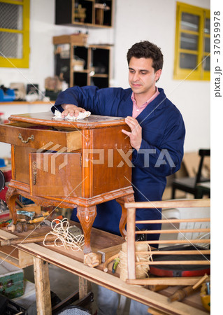 Craftsman inspecting nightstand before restoration 37059978