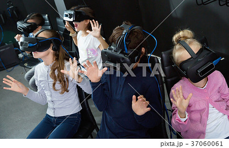 Enthusiastic children in virtual reality glasses in quest room Enthusiastic children in virtual reality glasses in quest room 37060061