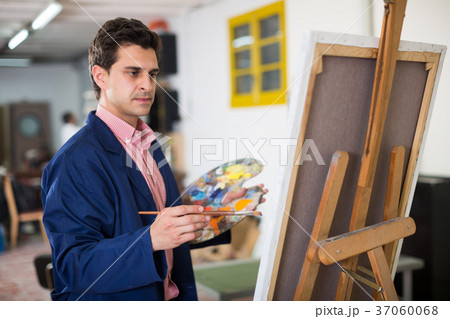 Man near easel painting on canvas Man near easel painting on canvas 37060068