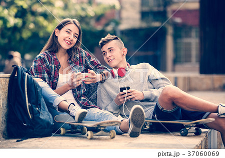 Teenager and his girlfriend with smartphones Teenager and his girlfriend with smartphones 37060069