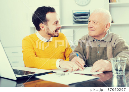 Man signing papers in office Man signing papers in office 37060297