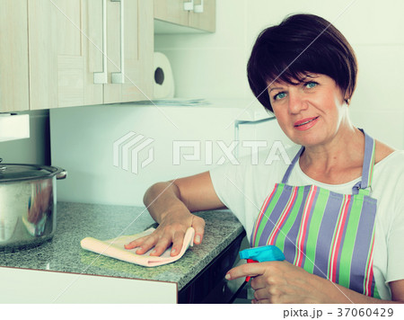 retiree woman cleaning home retiree woman cleaning home 37060429