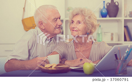 Happy elderly pair using laptop at home 37060791