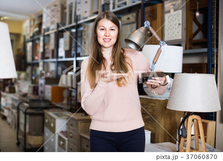 Portrait of cheerful woman buyer choosing modern lamp in furniture shop Portrait of cheerful woman buyer choosing modern lamp in furniture shop 37060870