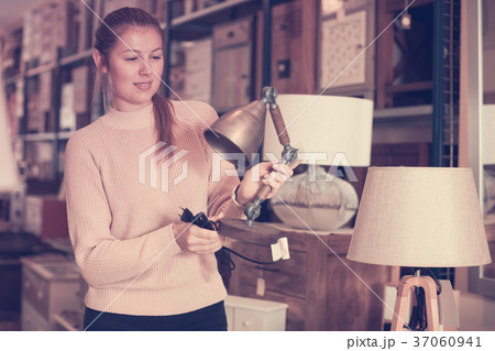 cheerful woman buyer choosing lamp 37060941