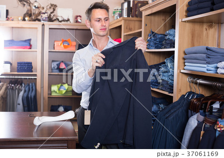 Male is deciding on for new dark blue suit 37061169