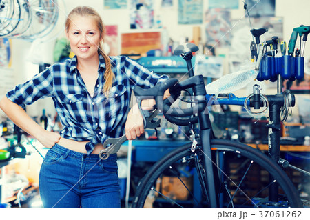 Portrait of adult girl who is fixing her bicycle Portrait of adult girl who is fixing her bicycle 37061262