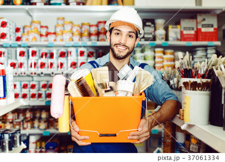 Workman holding basket with picked tools in paint store 37061334