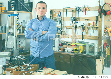 Portrait of attractive smiling adult man in garage. Portrait of attractive smiling adult man in garage. 37061399