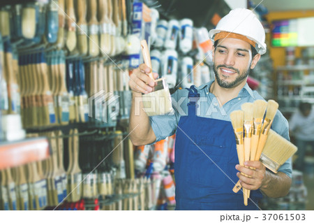foreman in blue overalls choosing brushes foreman in blue overalls choosing brushes 37061503