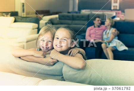 Portrait of smiling sisters are standing near new sofa 37061792