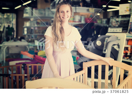 Nice pregnant woman choosing cot for baby Nice pregnant woman choosing cot for baby 37061825