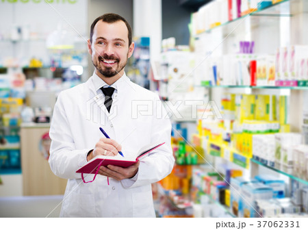 Pharmacist writing down assortment of drugs Pharmacist writing down assortment of drugs 37062331