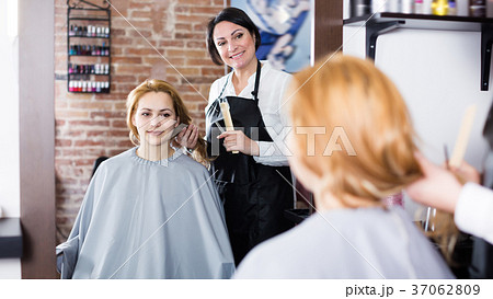 Young woman decides with master how to cut hair 37062809