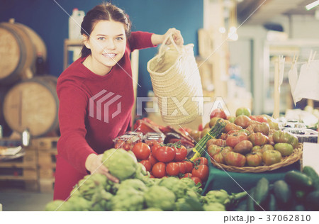 Woman decide on artichokes 37062810