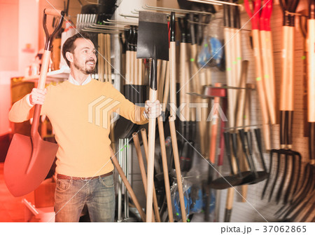 Ordinary guy deciding on best shovel Ordinary guy deciding on best shovel 37062865