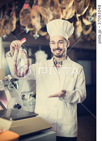 Male shop assistant using scales for sausage in butcher’s shop Male shop assistant using scales for sausage in butcher’s shop 37063048