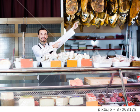Seller offering displayed sorts of meat 37063178