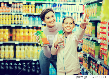 Female shopper with teenage daughter searching for beverages Female shopper with teenage daughter searching for beverages 37063251