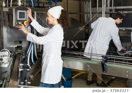 Couple bottling milk on manufacture 37063327