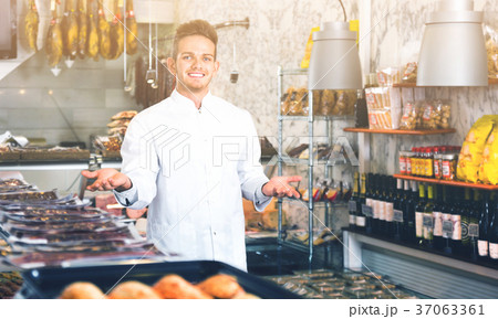 Shop-boy in special clothing shifting sausage 37063361