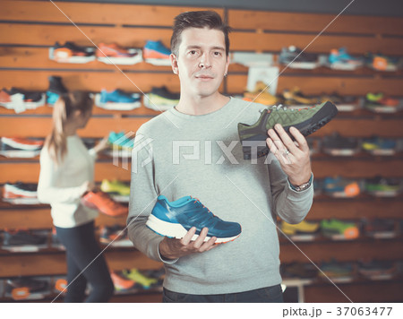 Glad man chooses shoes in shop Glad man chooses shoes in shop 37063477
