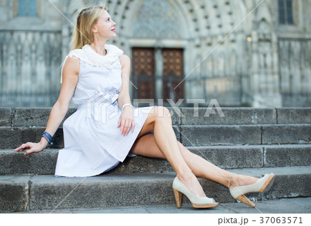 woman in shawl sitting on stone steps 37063571