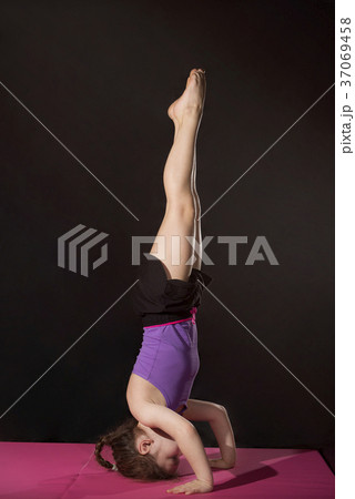 Little caucasian girl practing headstand pose 37069458