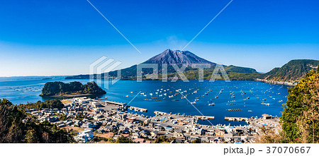 海潟の街並みと桜島_海潟漁港は桜島と江ノ島に囲まれた天然の良港で,港沿岸では養殖漁業が盛んである。 海潟の街並みと桜島_海潟漁港は桜島と江ノ島に囲まれた天然の良港で,港沿岸では養殖漁業が盛んである。 37070667