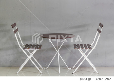 Small table and chairs near grunge wall Small table and chairs near grunge wall 37071202