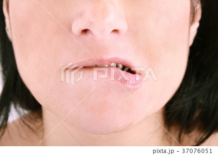 an embarrassed woman biting on her lip an embarrassed woman biting on her lip 37076051