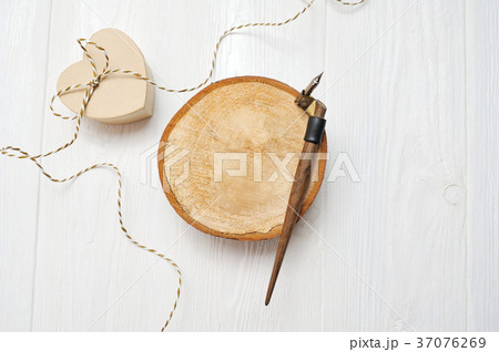 Calligraphic feather, lies on a wooden circle with Calligraphic feather, lies on a wooden circle with 37076269