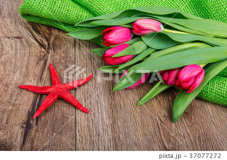 Starfish and tulips on a wooden table Starfish and tulips on a wooden table 37077272