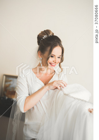 Gorgeous bride in robe posing and preparing for Gorgeous bride in robe posing and preparing for 37080666