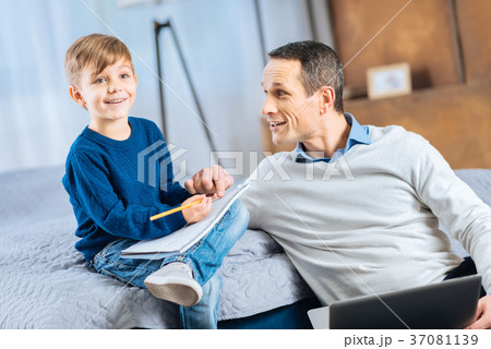 Cheerful father and son discussing ideas about 37081139