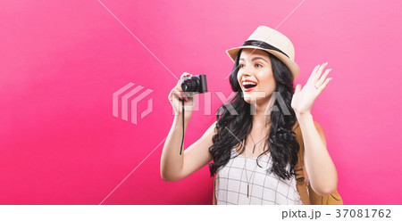 Traveling young woman holding a camera Traveling young woman holding a camera 37081762