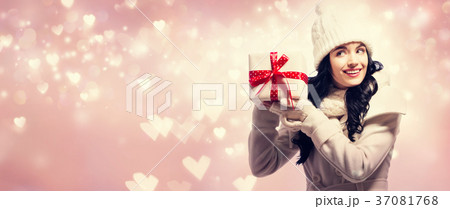 Young woman holding a Christmas gift Young woman holding a Christmas gift 37081768